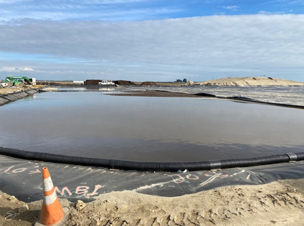 Cover system being pulled into place and view of perimeter gas collection pipe